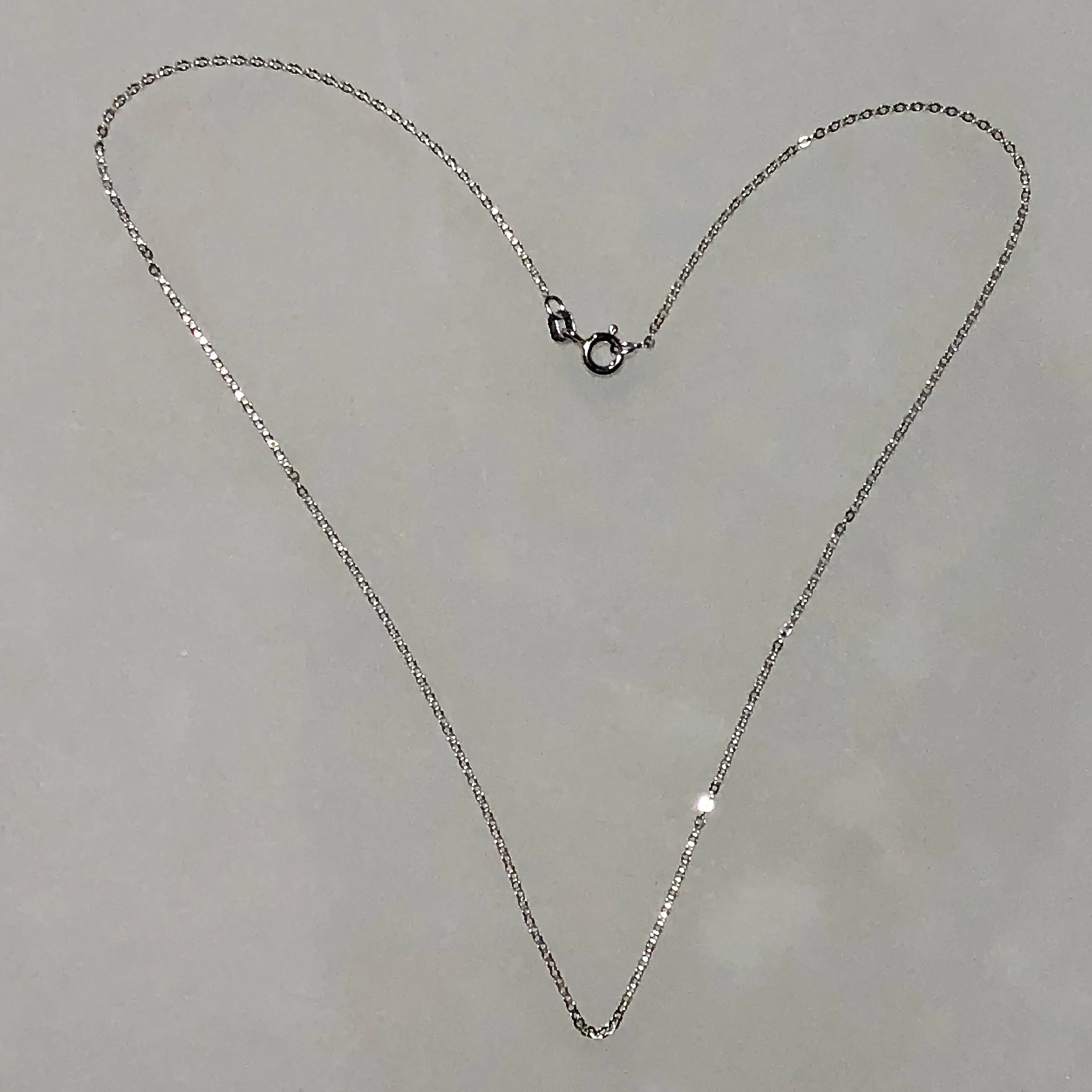 16, 18, and 20-inch slender Italian 925 sterling silver Diamond-Cut cable chain with spring ring clasp. Rhodium Plated.